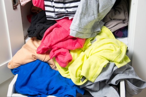 Staff member arranging commercial waste containers outside a Loughton business